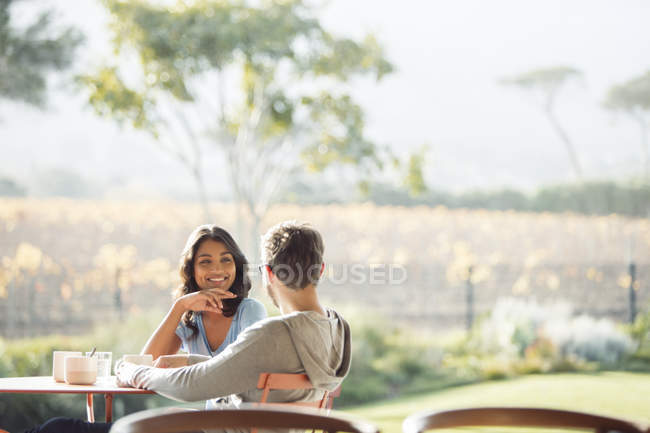Couple boire du café et parler sur le patio ensoleillé — Photo de stock
