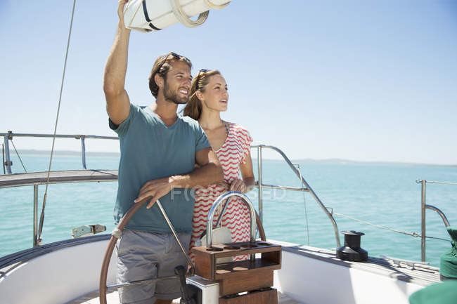 Couple steering boat together — Stock Photo
