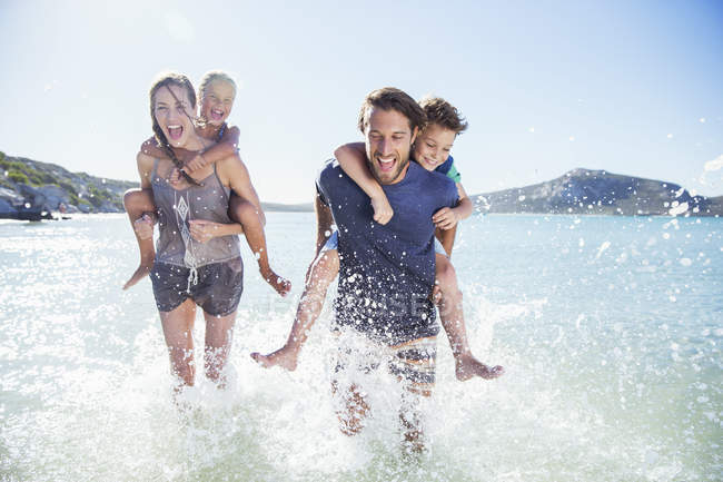 Сім'я біжить у воді на пляжі — стокове фото