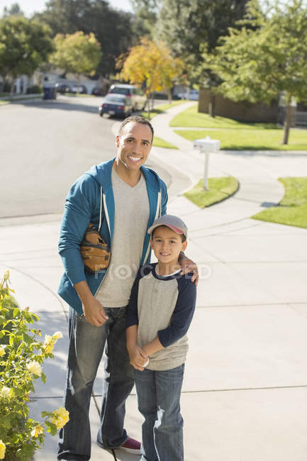 Retrato de pai e filho sorridentes na entrada de casa — Fotografia de Stock