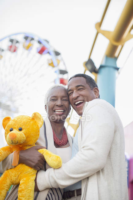 Retrato de pareja mayor sonriente en el parque de atracciones - foto de stock