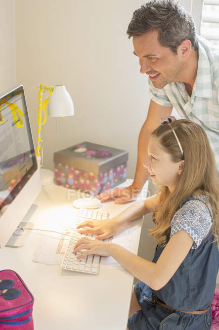 Батько і дочка використовують комп'ютер разом — стокове фото