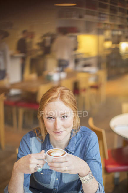 Woman drinking cup of coffee in cafe — Stock Photo