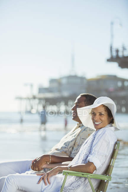 Портрет пари, що розслабляється в стільцях для газонів на сонячному пляжі — стокове фото