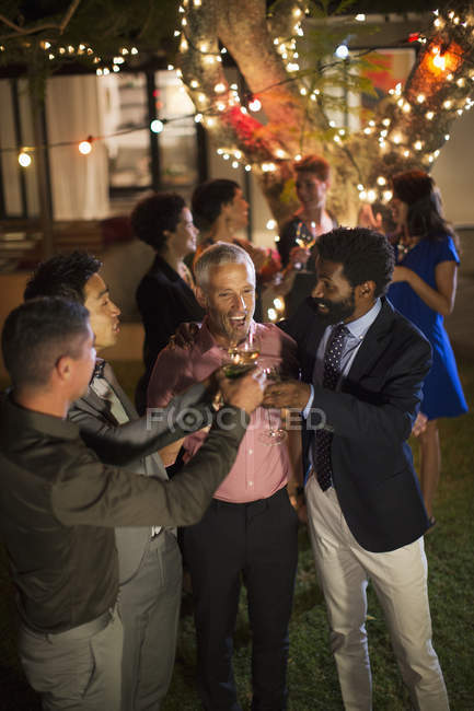 Hombres brindando entre sí en la fiesta - foto de stock