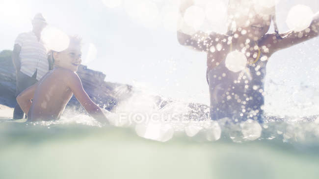 Famille jouer ensemble dans l'eau — Photo de stock
