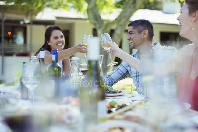 Amigos brindando entre sí en la cena al aire libre - foto de stock