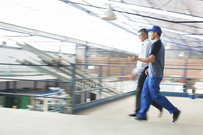 Superviseur et travailleur marchant dans une usine de transformation des aliments — Photo de stock