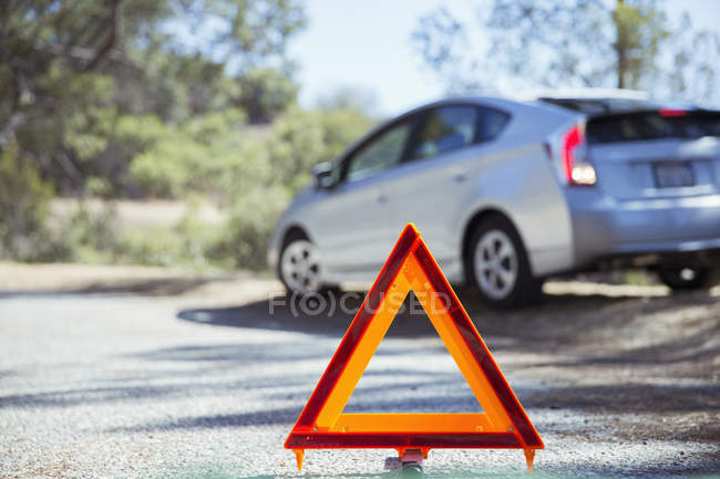 Voiture au bord de la route derrière triangle d'avertissement — Photo de stock