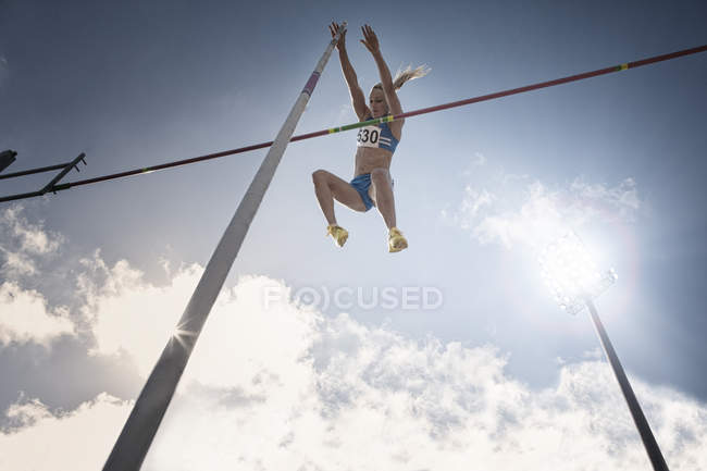 Pole vaulter clearing bar — Stock Photo