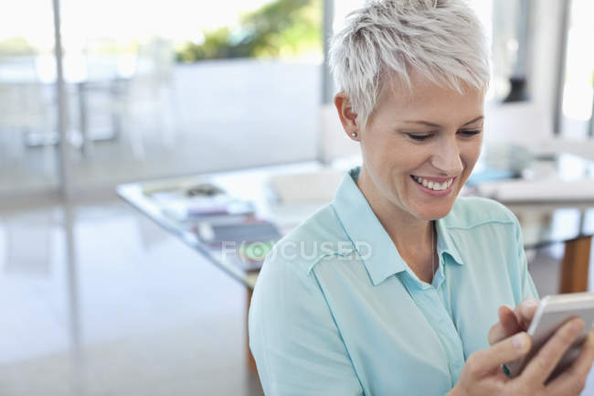 Geschäftsfrau nutzt Handy im modernen Büro — Stockfoto