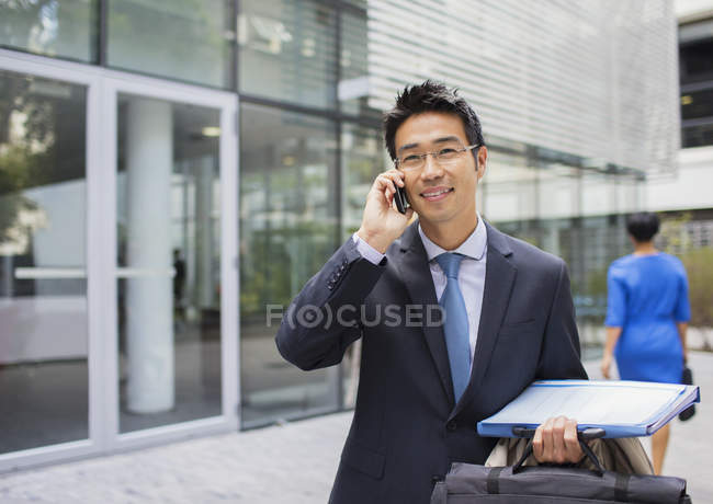 Uomo d'affari che parla al cellulare fuori dall'edificio degli uffici — Foto stock