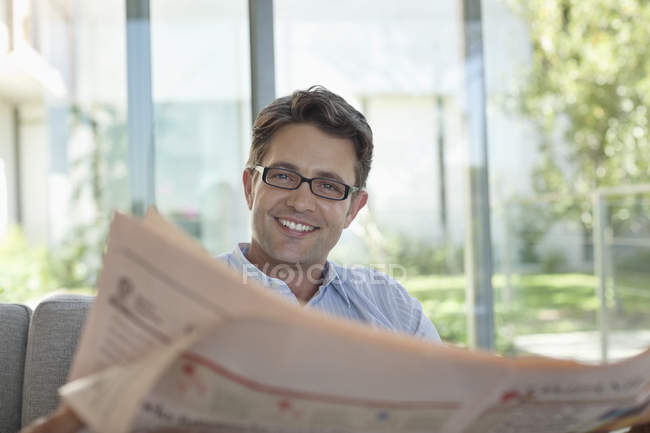 Бизнесмен читает газету на диване — стоковое фото