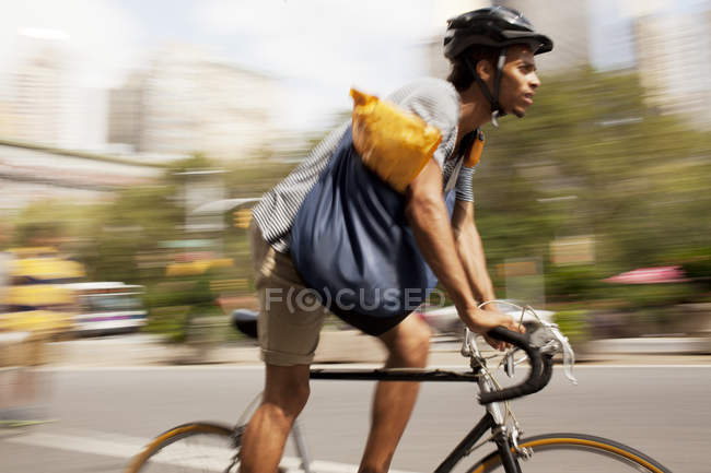 Man riding bicycle on city street — Stock Photo