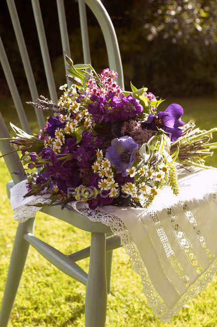 Bouquet of flowers in chair outdoors — Stock Photo