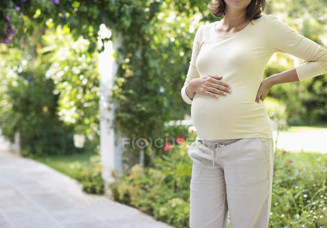 Pregnant woman standing outdoors — Stock Photo