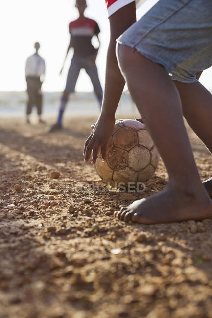 Africani ragazzi giocare a calcio insieme nel campo di sporcizia — Foto stock