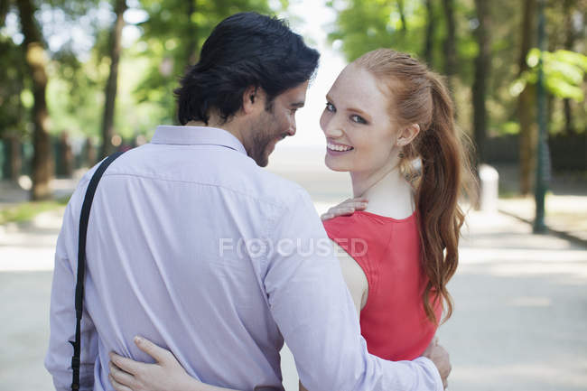 Портрет улыбающейся женщины, гуляющей с парнем в парке — стоковое фото