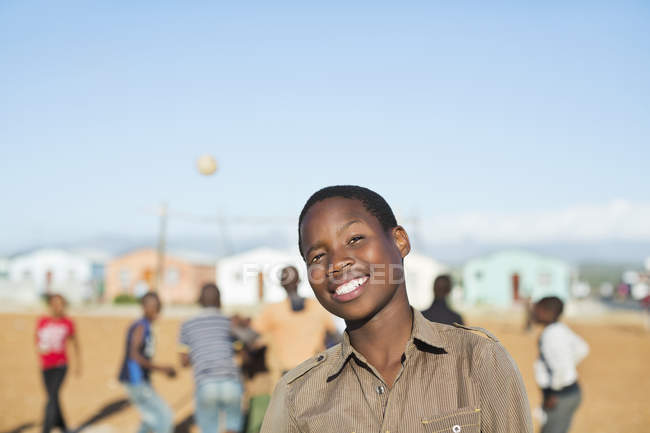Африканський хлопчик посміхається в ґрунтовому полі — стокове фото