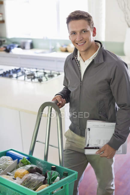 Skillful caucasian worker with delivery in kitchen — Stock Photo