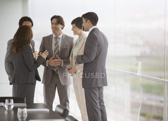 Gente de negocios hablando en la ventana de la sala de conferencias - foto de stock
