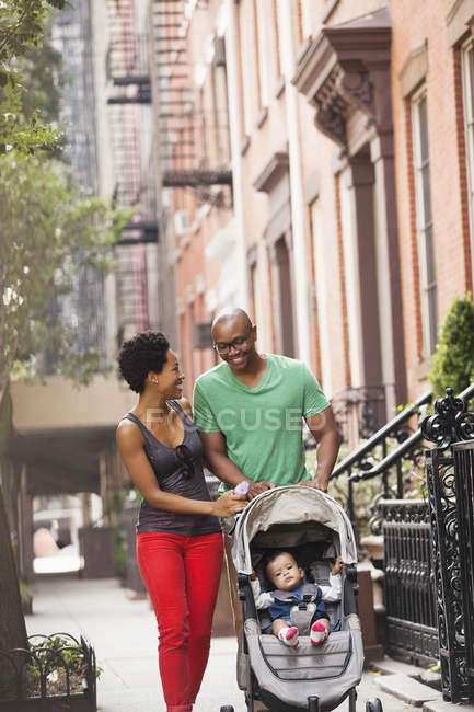 Familia caminando juntos en la calle de la ciudad - foto de stock