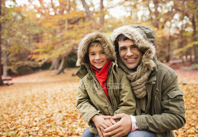 Père caucasien et fils souriant dans le parc — Photo de stock