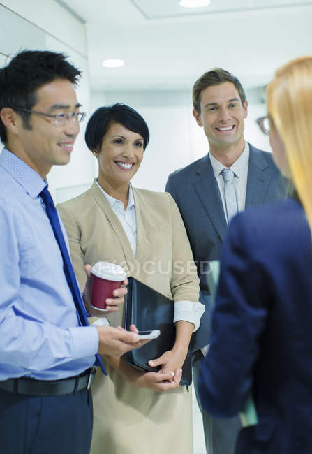 Gente de negocios hablando en edificio de oficinas - foto de stock