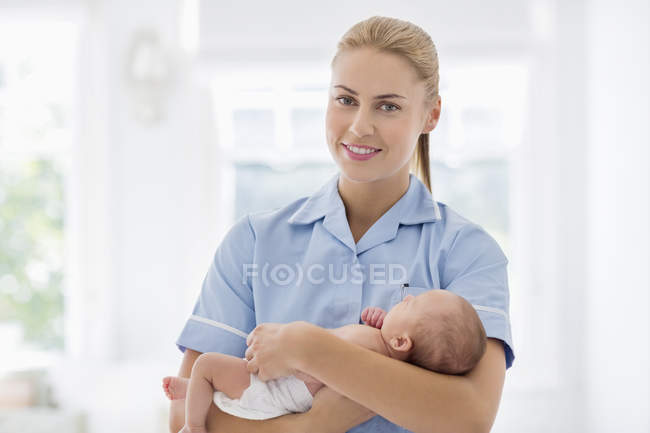 Медсестра держит новорожденного ребенка в больнице — стоковое фото