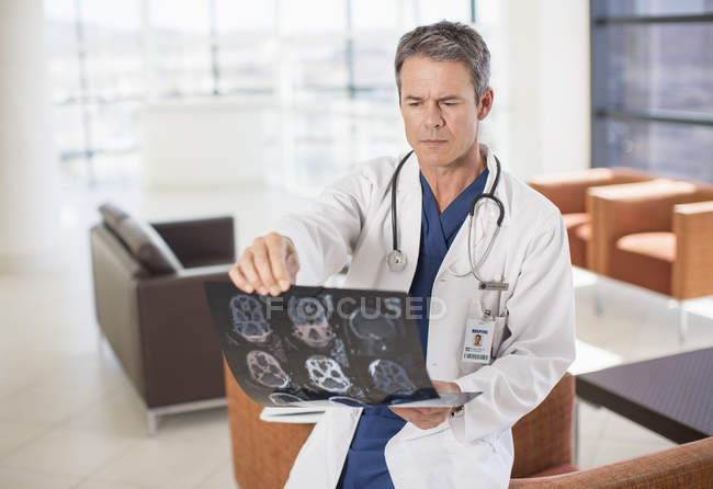 Médico viendo radiografías de la cabeza en el hospital - foto de stock