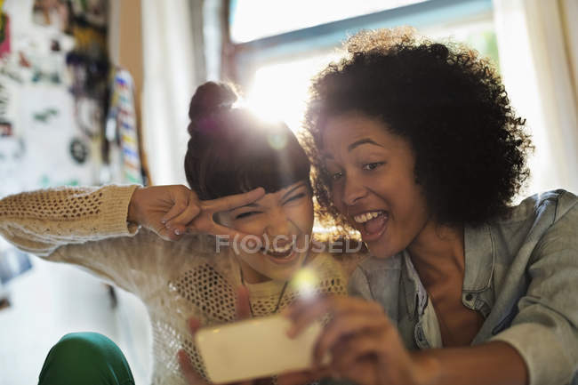Jóvenes mujeres felices tomando fotos juntos - foto de stock