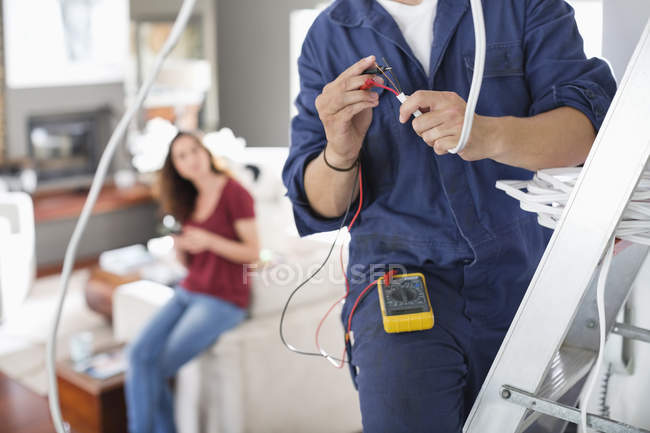 Hábil electricista trabajando en la sala de estar - foto de stock