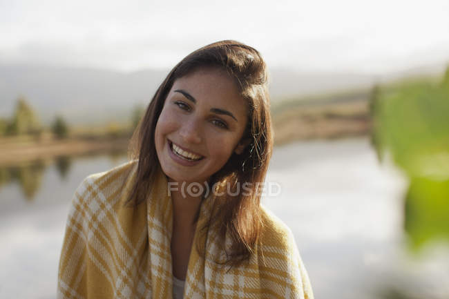 Retrato de mujer sonriente a orillas del lago - foto de stock