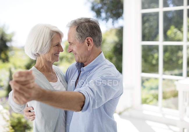 Senior caucasian couple dancing on patio — Stock Photo
