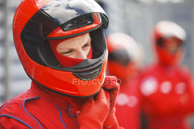 Racer tying on helmet on track — Stock Photo