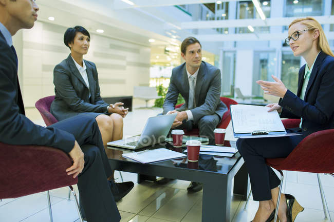 Les gens d'affaires parlent en réunion dans un immeuble de bureaux — Photo de stock