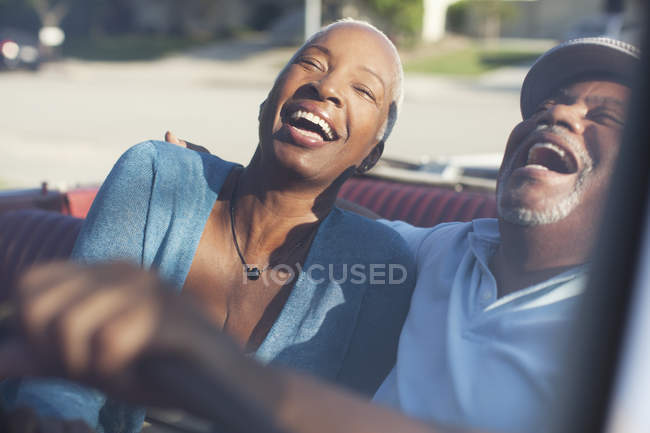 Пожилая пара смеется в кабриолете — стоковое фото