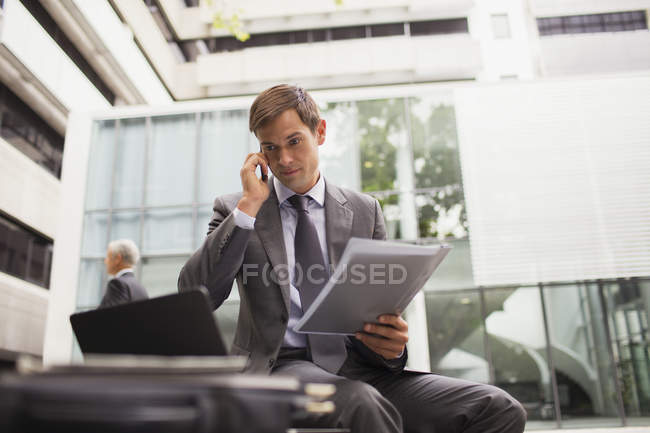 Бизнесмен работает на скамейке в офисном здании — стоковое фото