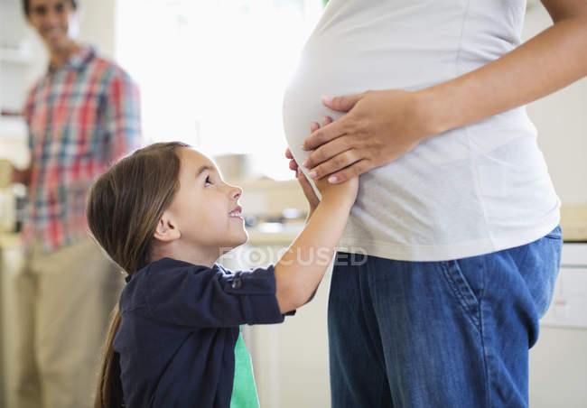 Chica sosteniendo las madres embarazadas vientre - foto de stock