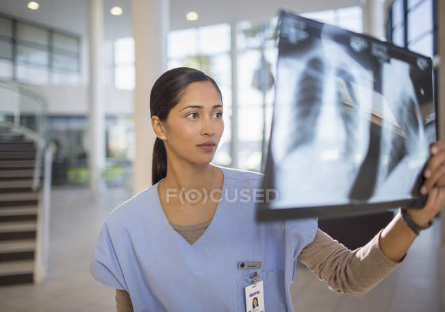 Infermiera che esamina le radiografie del torace in ospedale — Foto stock