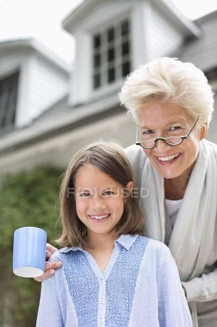 Mulher e neta sorrindo juntas ao ar livre — Fotografia de Stock