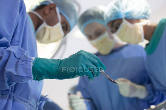 Хирург держит нож в операционной — стоковое фото