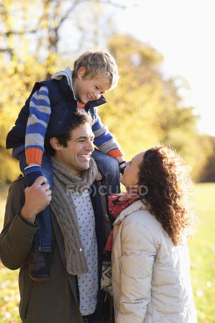 Familia feliz sonriendo juntos en el parque - foto de stock