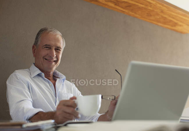 Homme plus âgé prenant une tasse de café au bureau — Photo de stock
