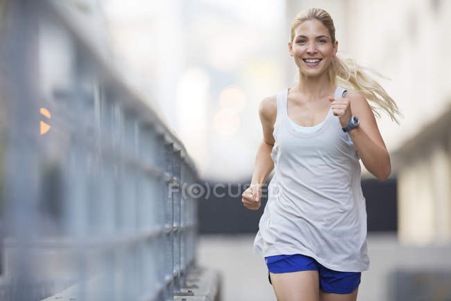 Woman running through city streets — Stock Photo