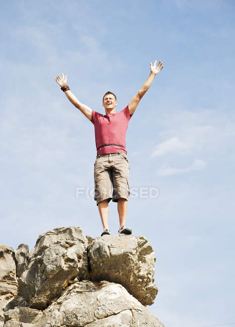 Kaukasischer Bergsteiger jubelt auf felsigem Gipfel — Stockfoto