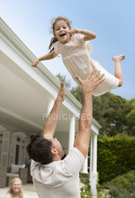Отец и дочь играют вне дома — стоковое фото