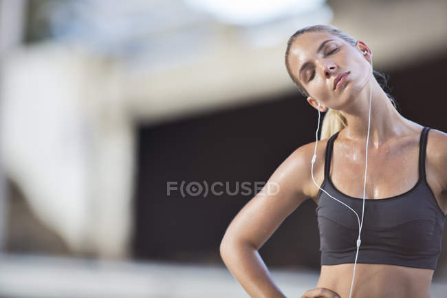 Woman stretching with eyes closed after exercise — Stock Photo