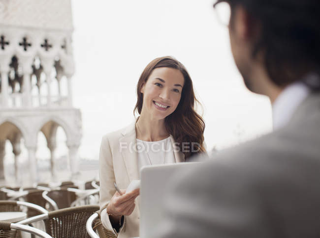 Femme d'affaires souriante rencontre avec un homme d'affaires au café trottoir — Photo de stock