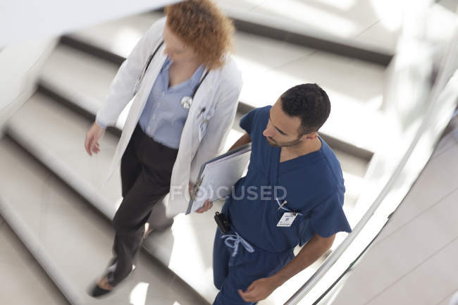 Médecin et infirmière marchant sur les marches de l'hôpital — Photo de stock